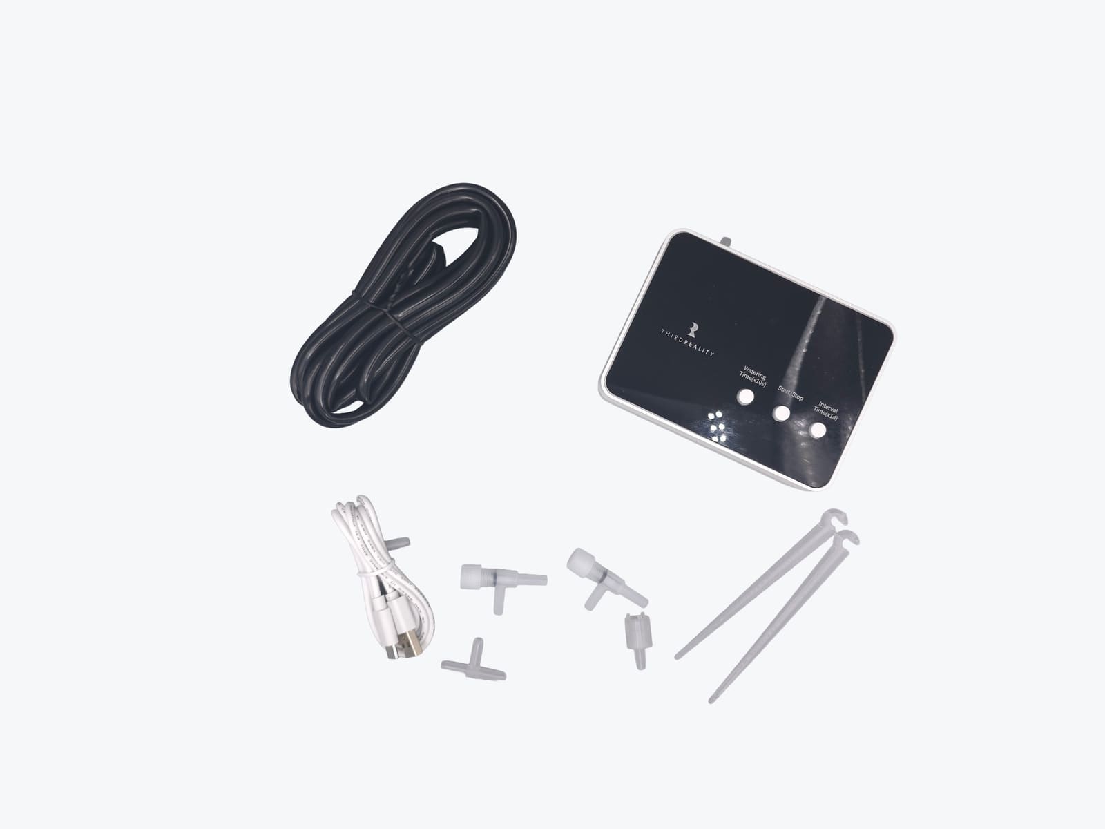 Third Reality Smart Watering Kit Pro unboxed, showing the valve unit, tubing, drip stakes and splitters laid out