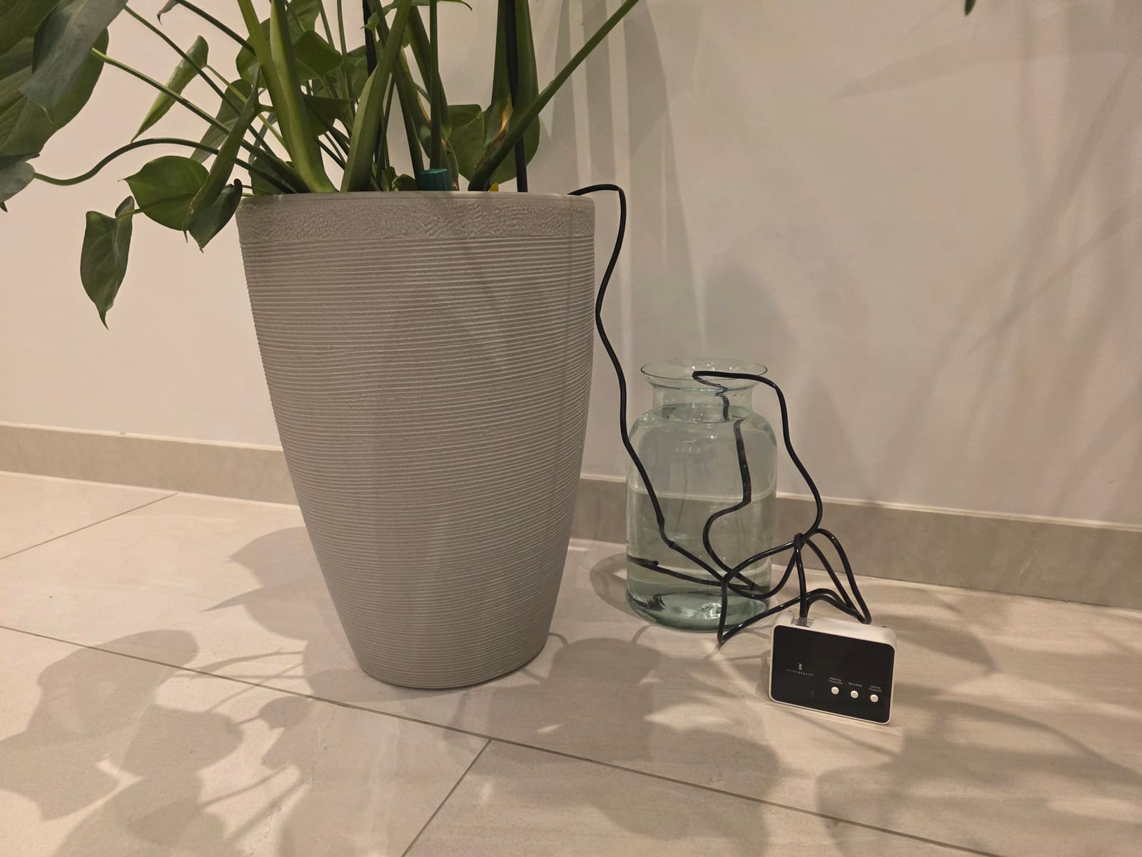 Third Reality Smart Watering Kit Pro valve installed next to a potted plant with the drip tube in the soil