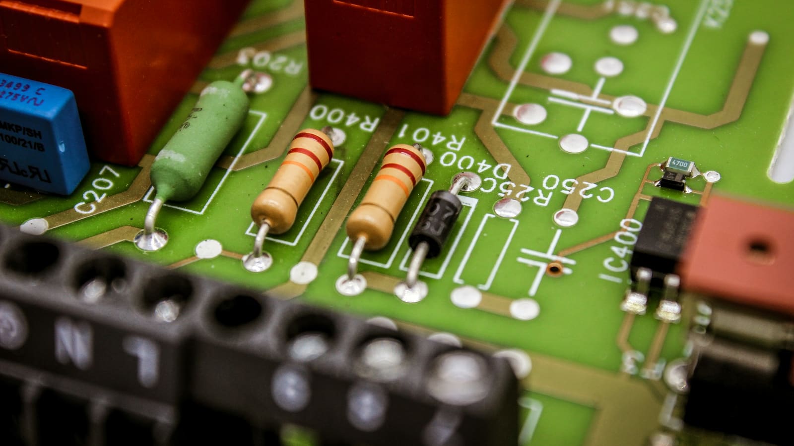 Close-up of a green electronic circuit board with small components and chips