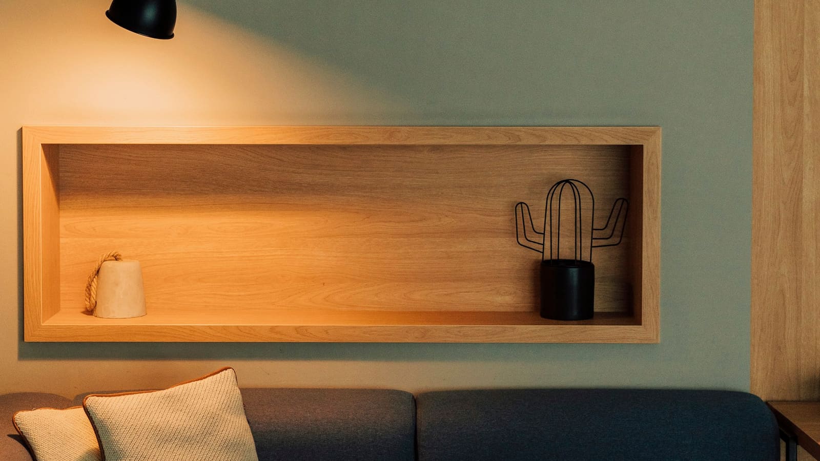Cosy living room with a sofa and a lit table lamp beside it