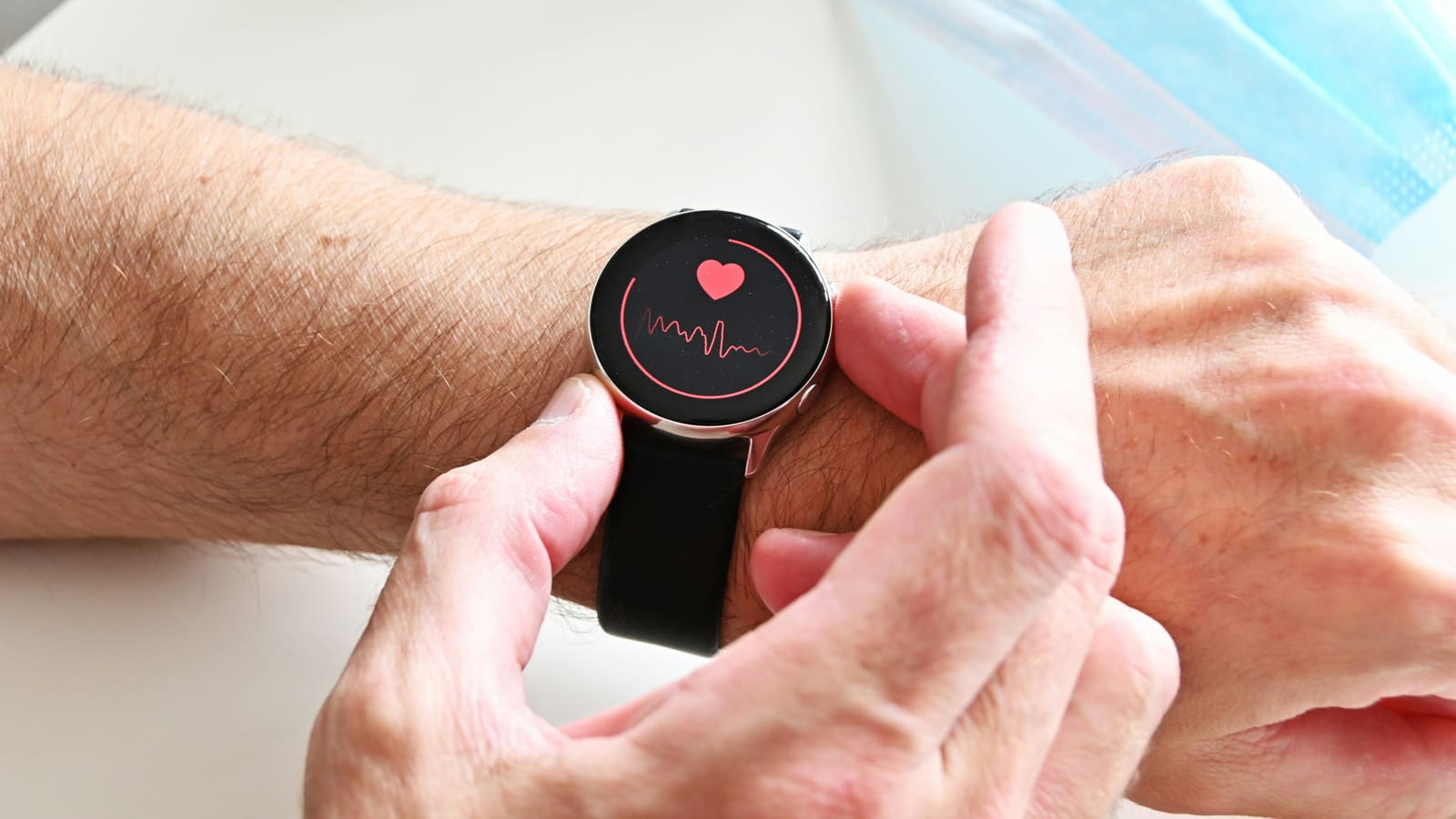 Person checking heart rate readings on a smartwatch worn on their wrist